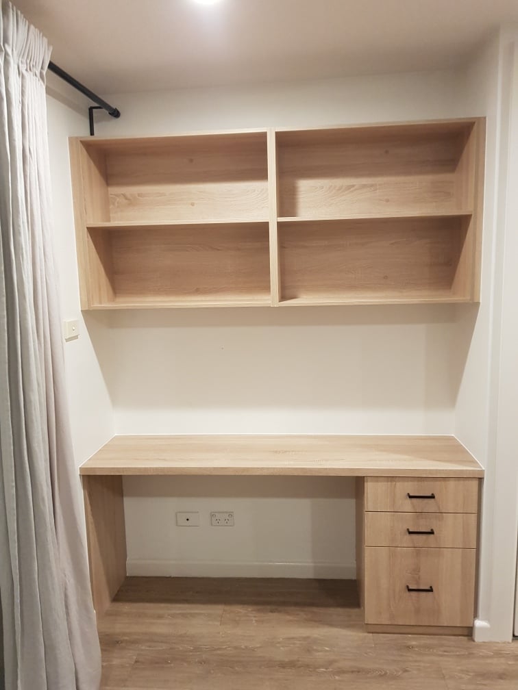 Custom built-in cabinetry with open shelving and drawers in a home study nook