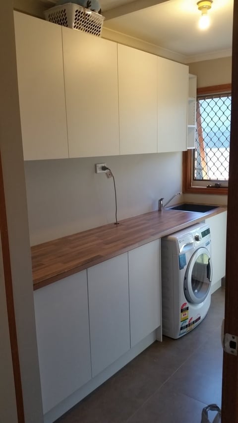 Custom laundry cabinetry with white cupboards and timber benchtop on the Mornington Peninsula