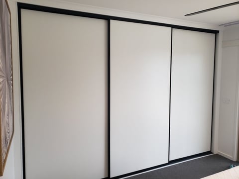 Modern custom wardrobe with white sliding doors installed in a Mornington bedroom