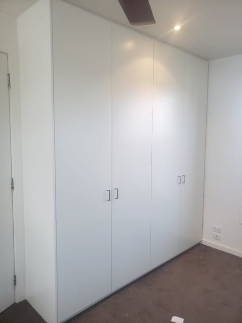 White built-in wardrobe with cabinet doors installed in a Mornington home