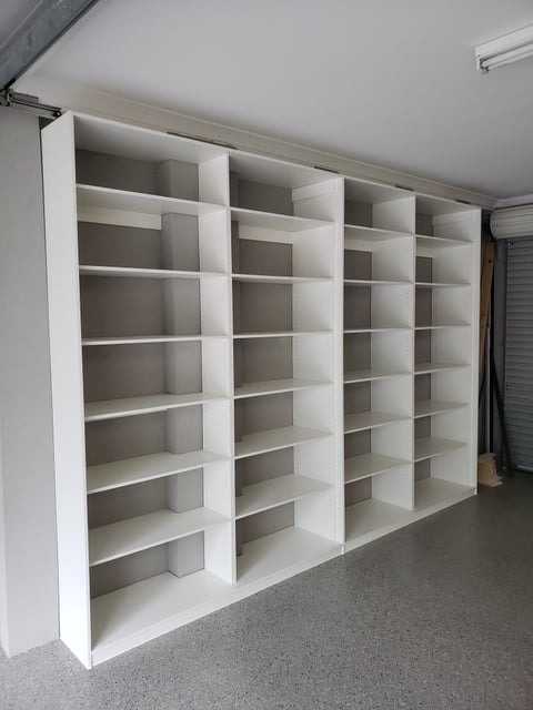 Custom white storage cabinetry with adjustable shelving and drawers by The Wardrobe Guy