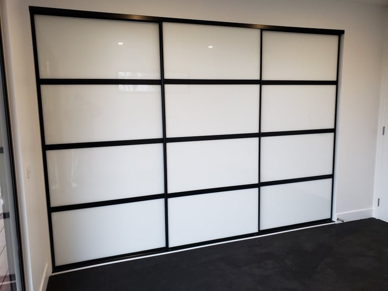Modern sliding wardrobe doors with black metal frame and frosted glass panels