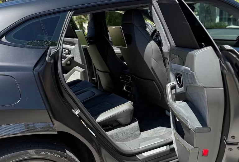 Open car door showing interior with white and black two-tone seats in daylight