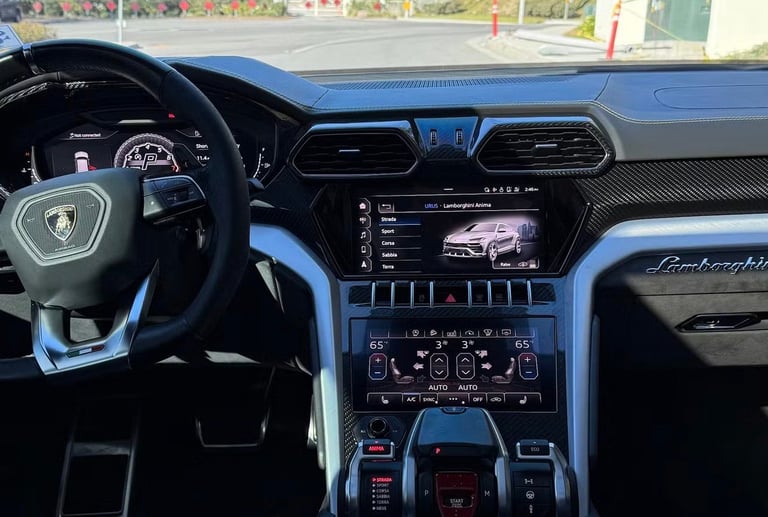 Luxury supercar interior with steering wheel, digital display showing engine specs, and high-tech dashboard with blue accents