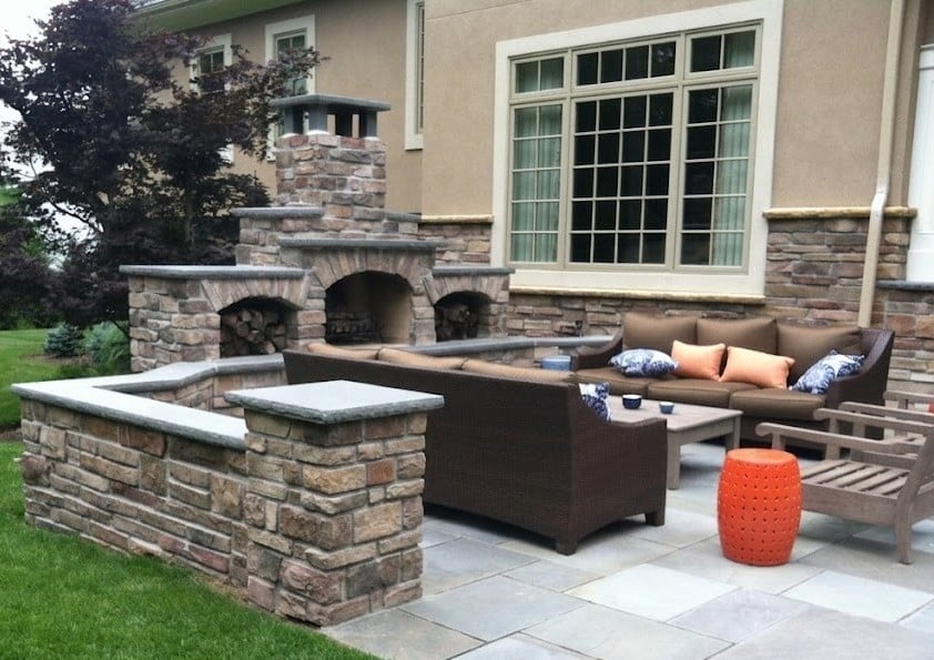 Outdoor patio with stone fireplace and built-in seating