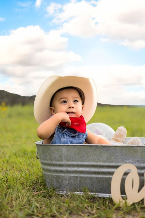 Andrés con sombrero vaquero en una tina en un campo verde