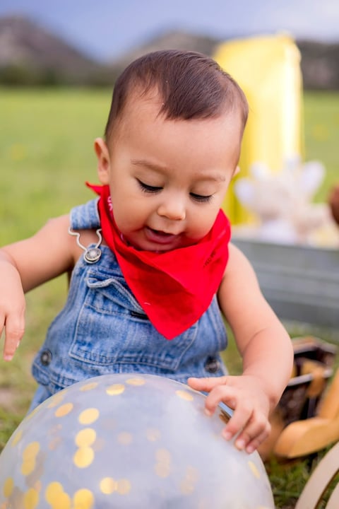 Andrés jugando con un globo en un campo verde