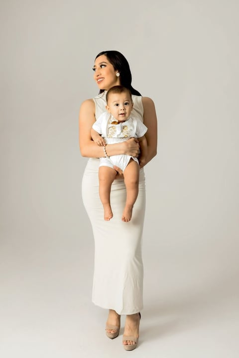 Mamá con vestido blanco sosteniendo a Andrés