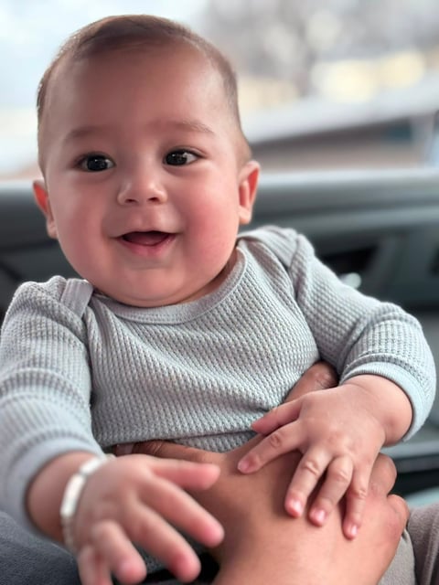 Bebé Andrés sonriendo en suéter gris