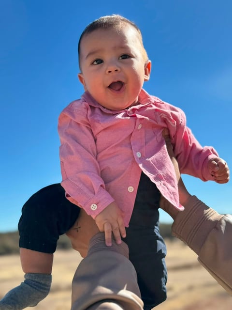 Andrés en camisa rosa sonriendo al aire libre