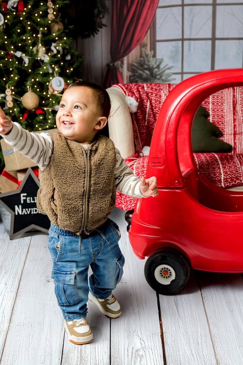 Andrés junto a un camioncito rojo en sala de Navidad