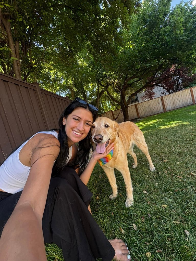 Bre Helm of Walks With Love smiling with a golden retriever during a pet sitting visit in Sandy Utah