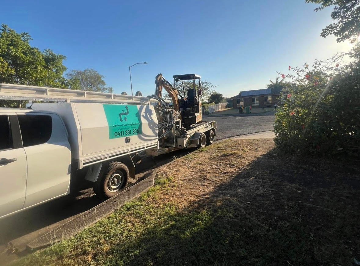 Glorious Plumbing Services truck and excavator on a residential job in Rosewood