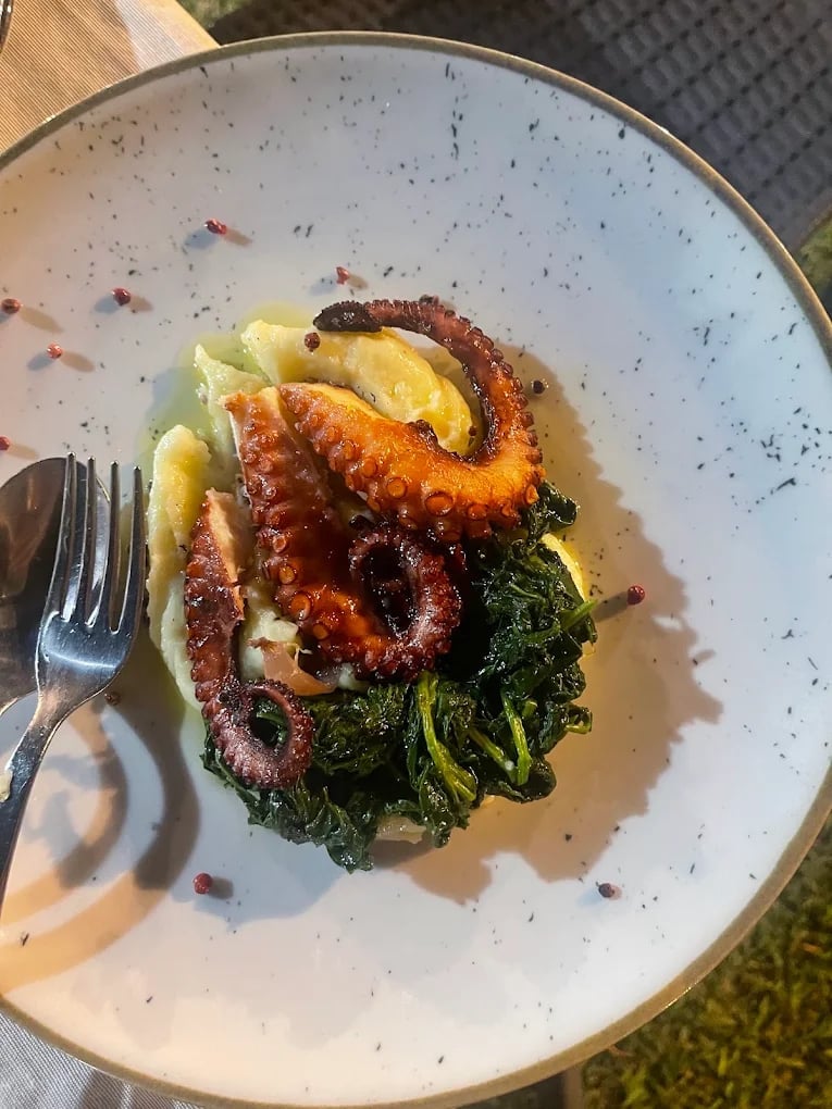 Piatto di polpo scottato con verdure in padella, patate e peperoncino