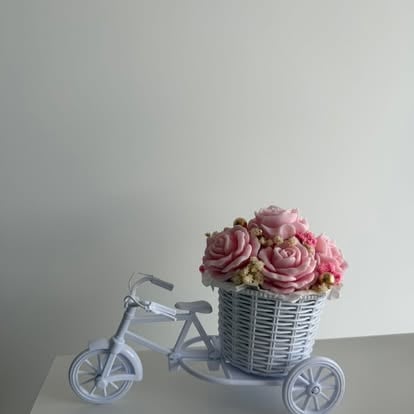Dekoracyjny flowerbox NEORA z różowymi różami w wiklinowym koszyku na białym rowerku