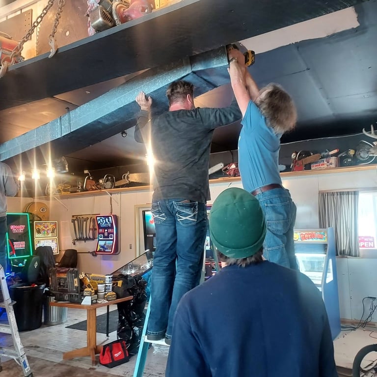 Before and after photos showing structural beam installation in an arcade or game room during and after construction