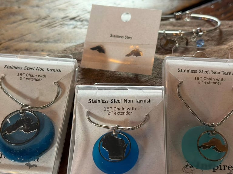 Three stainless steel non-tarnish necklaces with pendants displayed on packaging cards with 18-inch chains and extenders