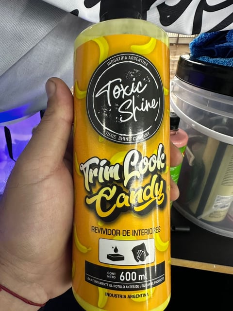 Hand holding a 600ml bottle of Toxic Shine Trim Cool Candy car interior cleaner from Argentina