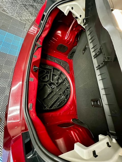 Open red car taillight assembly showing internal wiring and components against black backing panel