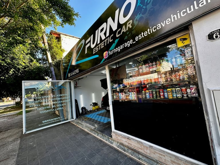 Exterior of Furno Garage car cosmetic shop with dark storefront, signage, and product displays visible through windows on a sunny day