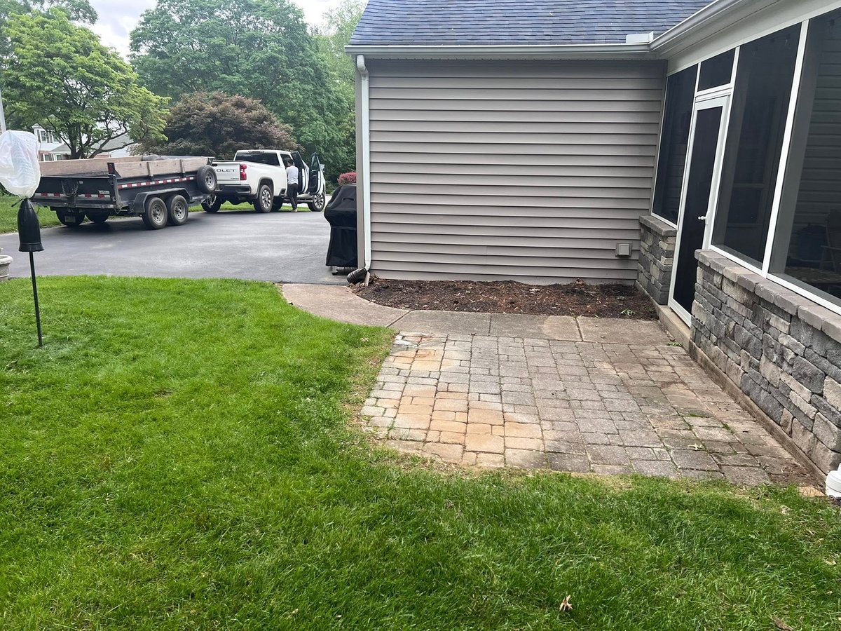 Old worn concrete pavers behind residential home before renovation