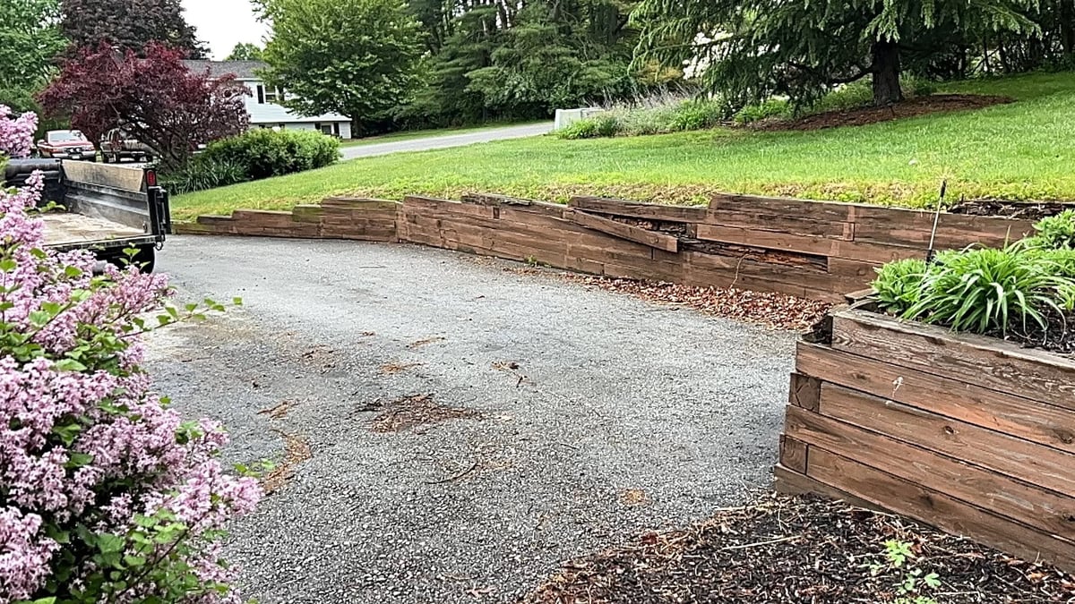 Yard under construction with excavator and stacked stone boulders