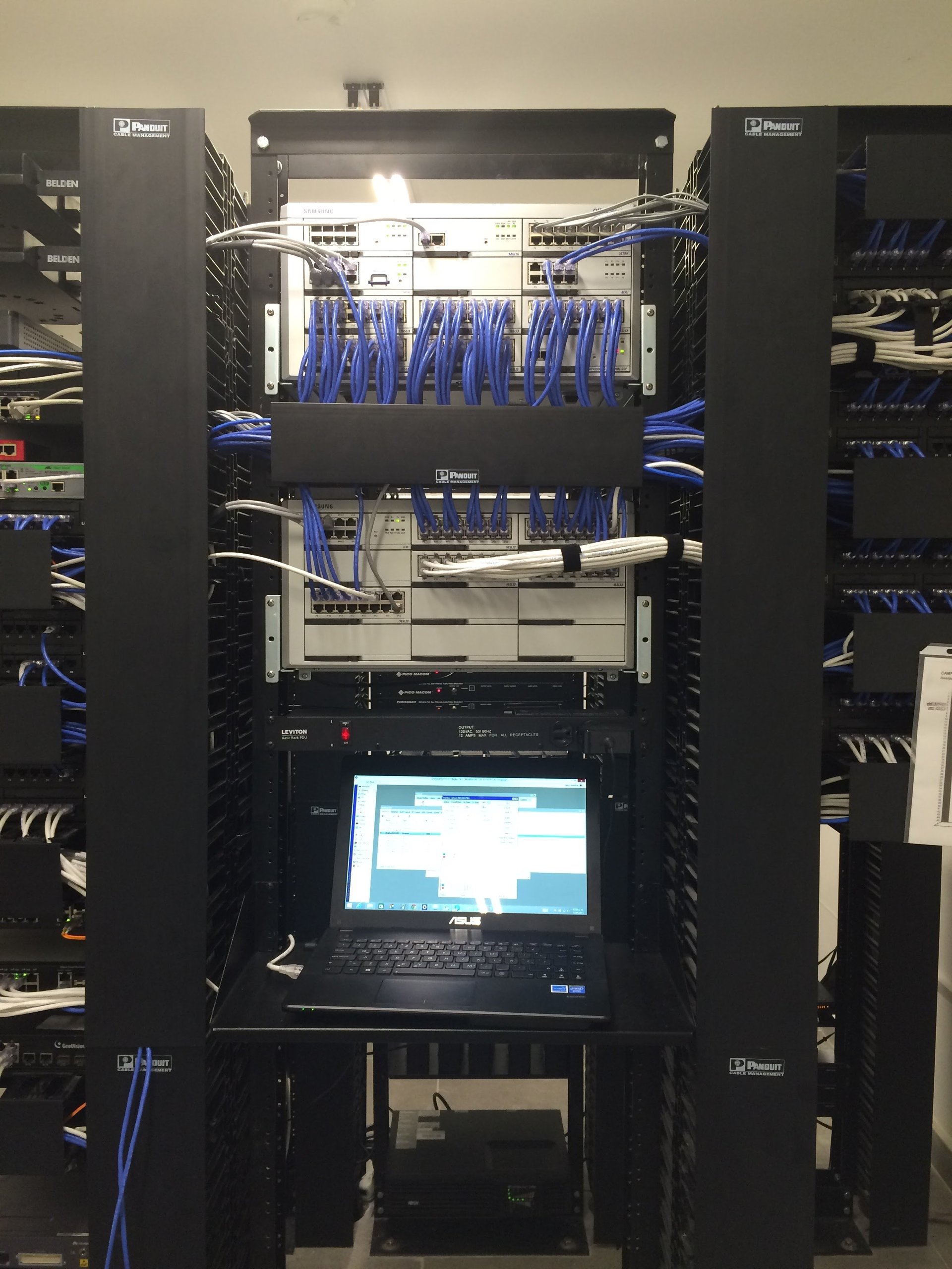 Rack de servidores y comunicaciones de My Digital Manager con switches, patch panels y cableado estructurado organizado, en un cuarto de datos climatizado