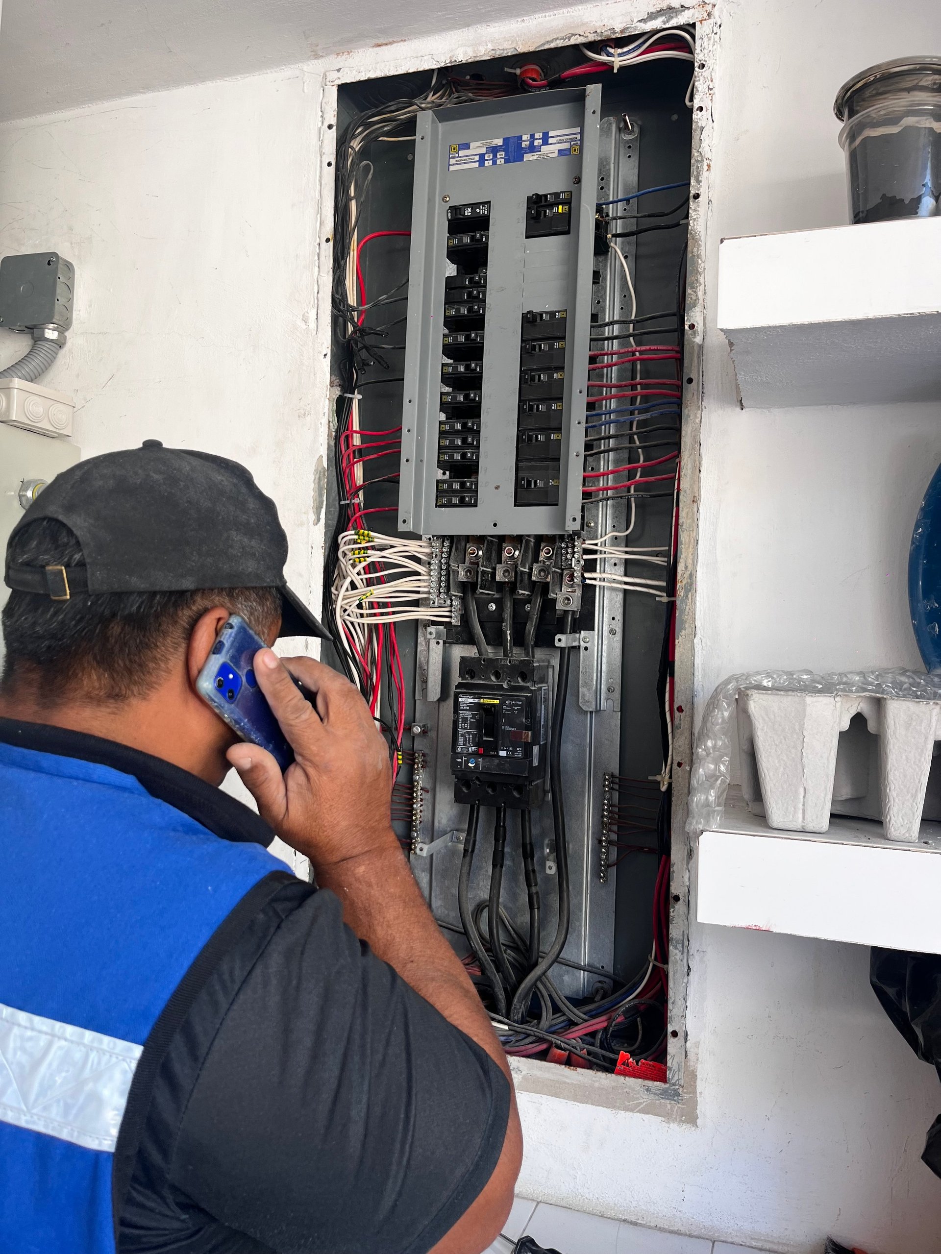 Especialista revisando un tablero con circuitos y protecciones en la instalación de una empresa