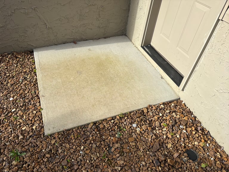White concrete pad or threshold installed on gravel surface at garage door entrance
