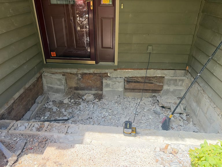 Unfinished concrete foundation under a house with wooden door frame and exposed basement walls during construction