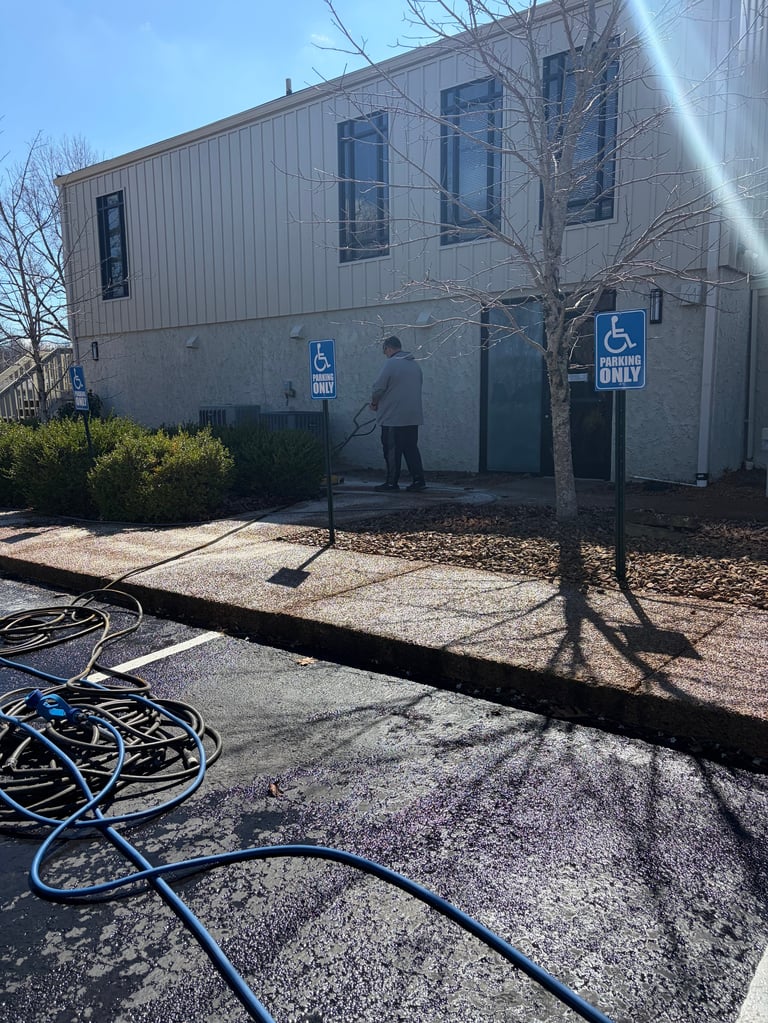 Modern gray metal commercial building with disabled parking signs and bare trees in parking lot