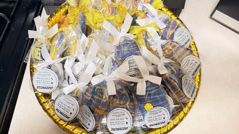 Gold and white platter filled with individually wrapped treats and candies with labeled stickers