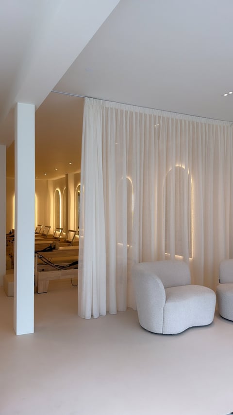 Modern minimalistisch interieur met witte gordijnen, gebogen stoelen en architecturale zuil