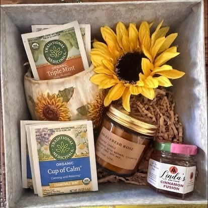 Assorted gift box with dried sunflower, herbal tea packets, organic honey jar, and cinnamon spread