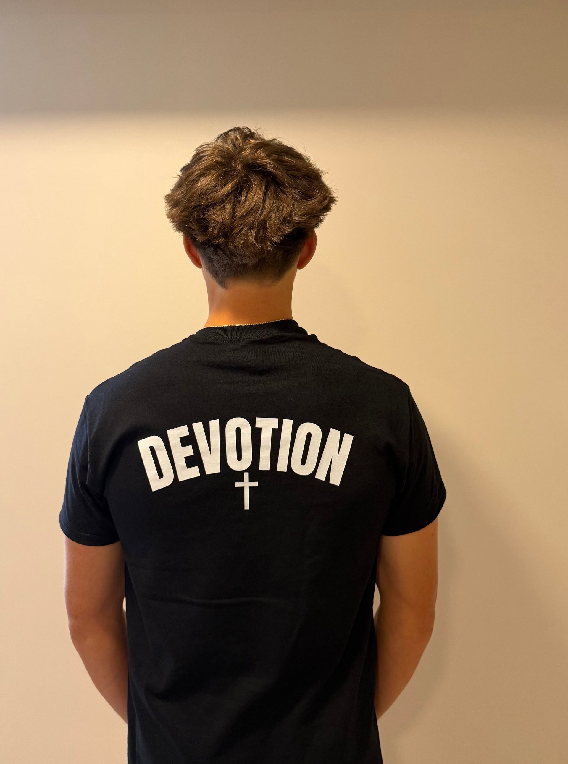 Model wearing the DEVOTION plus cross Disciplined Devotion tee, back view