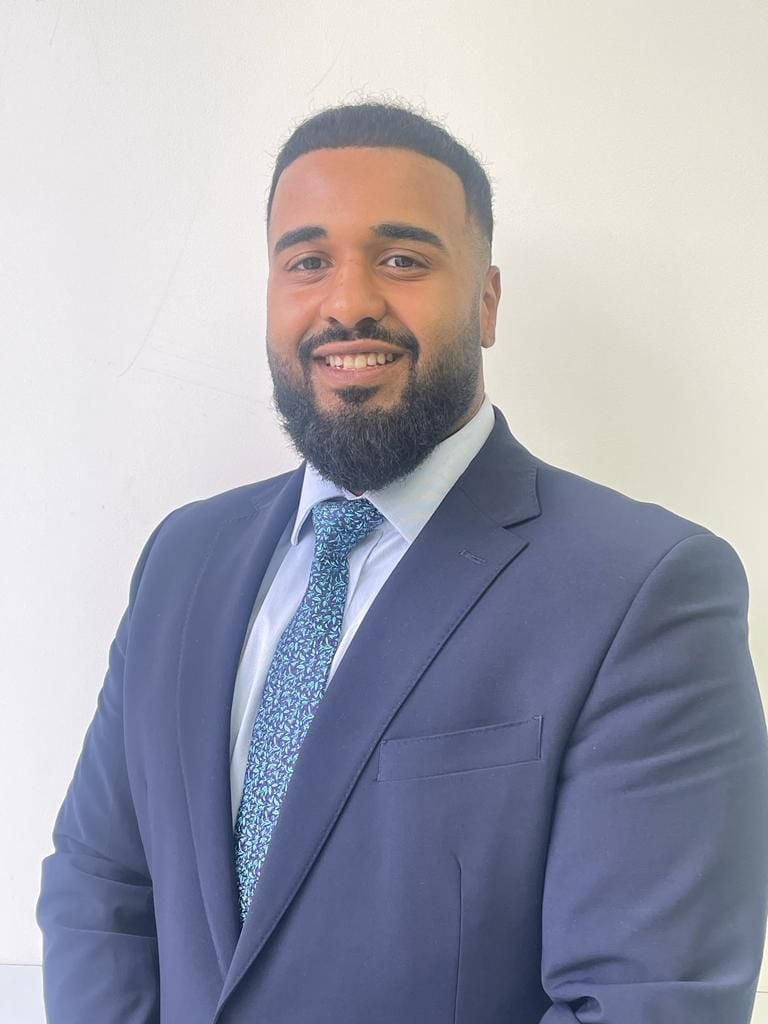 Mohamed Osman, solicitor at Legalise It Solicitors, professional headshot wearing a navy blazer and blue patterned tie against a white background