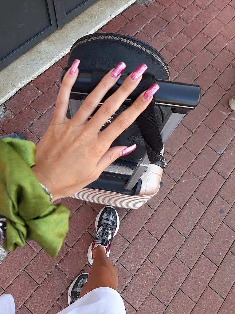 Manicure sfumata rosa e nera su mano in strada