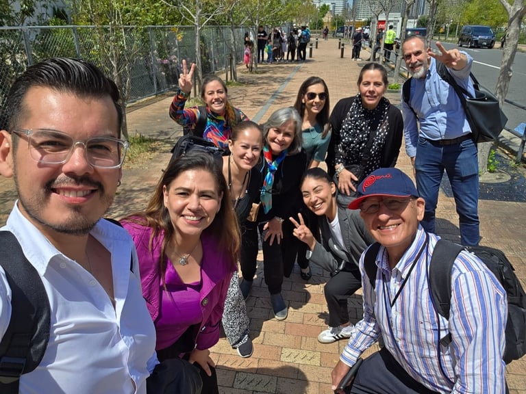 Group of diverse people smiling at camera outdoors on a paved path during daytime event