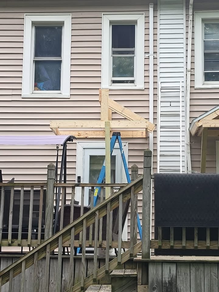 Wooden deck with blue ladder leaning against house siding during renovation or construction work