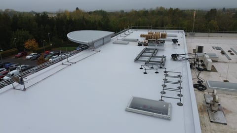 Flat commercial building roof with white membrane