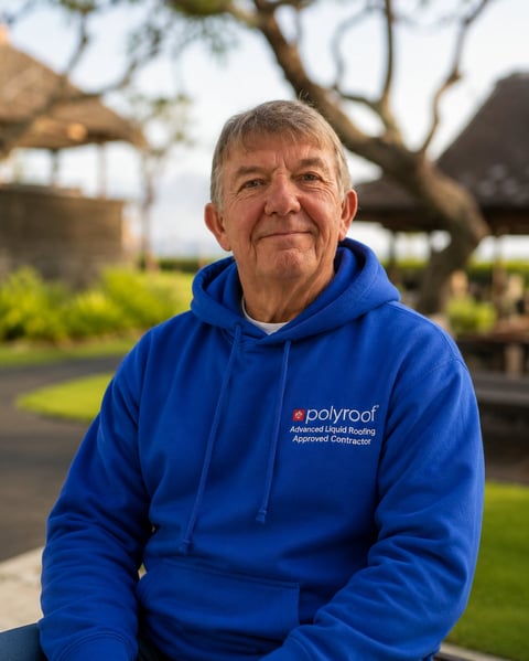 Older man wearing blue Polyroof hoodie smiling at camera outdoors with tree and garden in background