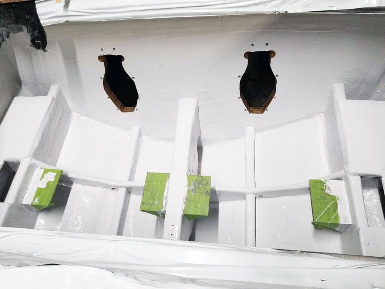 White compartmentalized bilge tray in the P-29 hull with two stern drive cutouts and green support blocks