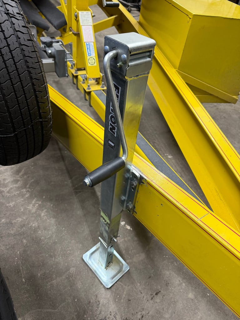 New heavy-duty Fulton trailer jack with hand crank mounted on the yellow trailer tongue, replacing the old welded-on jack