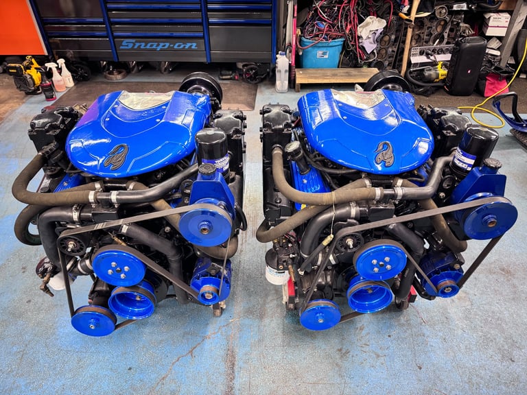 Twin blue turbocharged engines on display in the garage workshop, surrounded by toolboxes and equipment