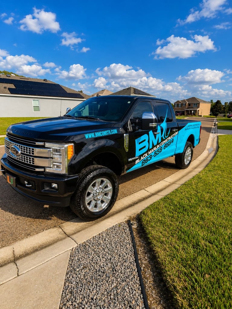 Black and blue Ford Super Duty pickup truck with BMM branding parked in suburban driveway on sunny day
