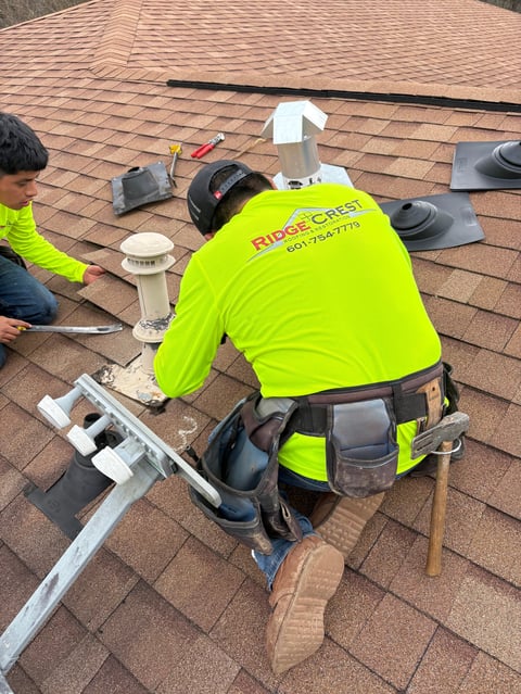 RidgeCrest roofer in safety vest installing shingle roof