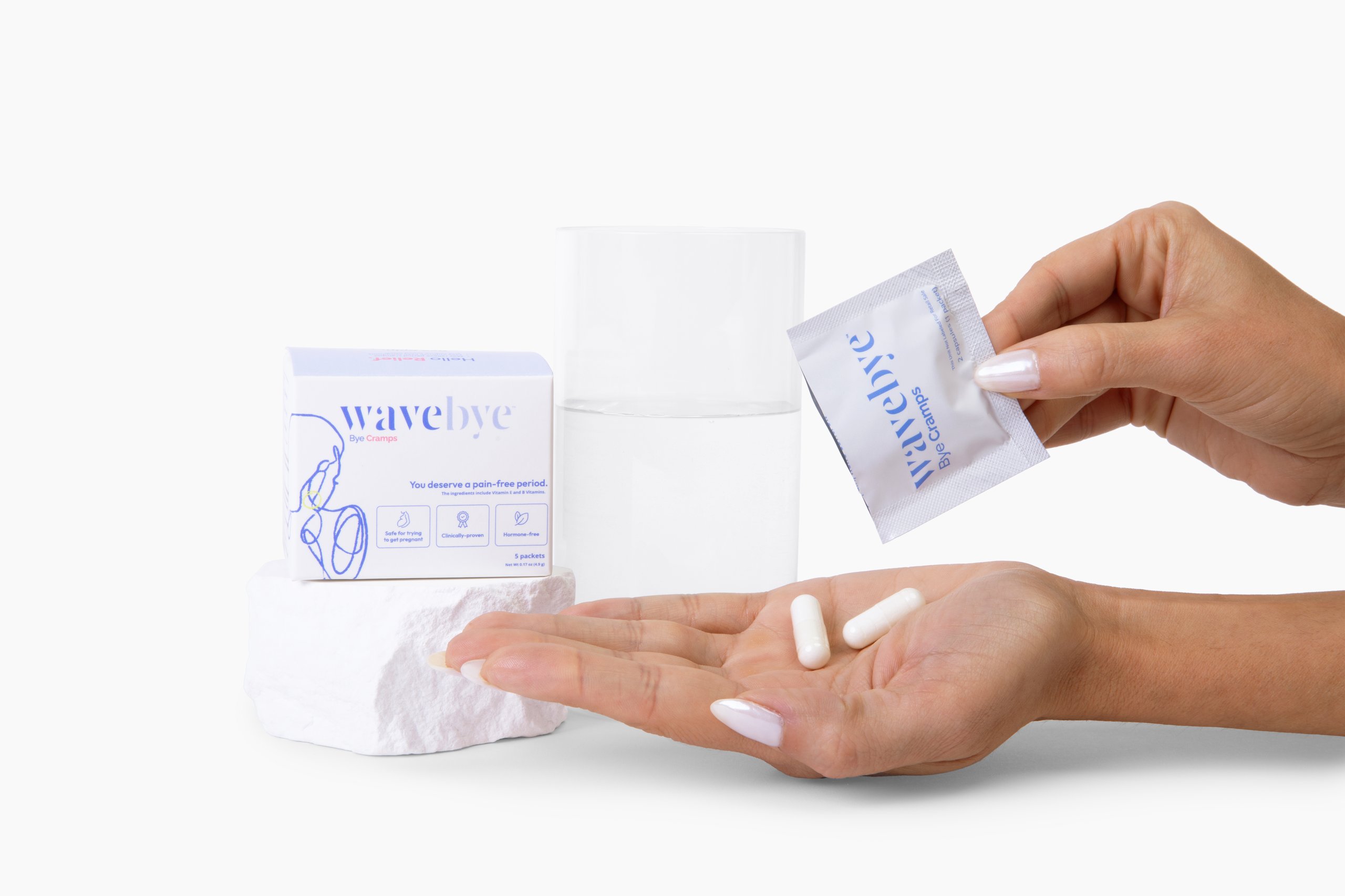 Two hands applying wavebye skincare product, with jar and packet displayed against white background