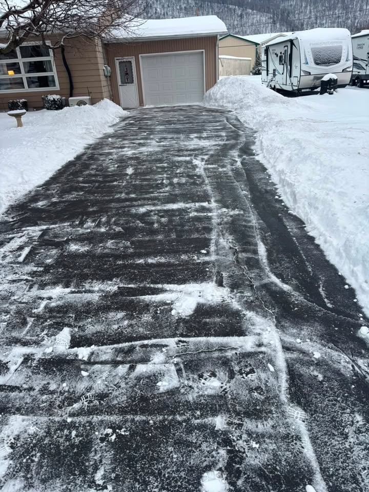 Driveway completely cleared of snow with neat piles on either side after JC'S professional snow removal