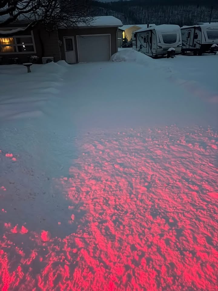 Snowy property at dusk with heavy snow accumulation before JC'S snow removal service