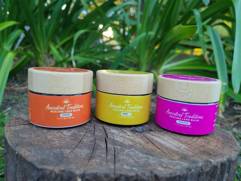 Three Ancestral Traditions Healing Lard Balm jars with wooden lids arranged on a tree stump in a garden